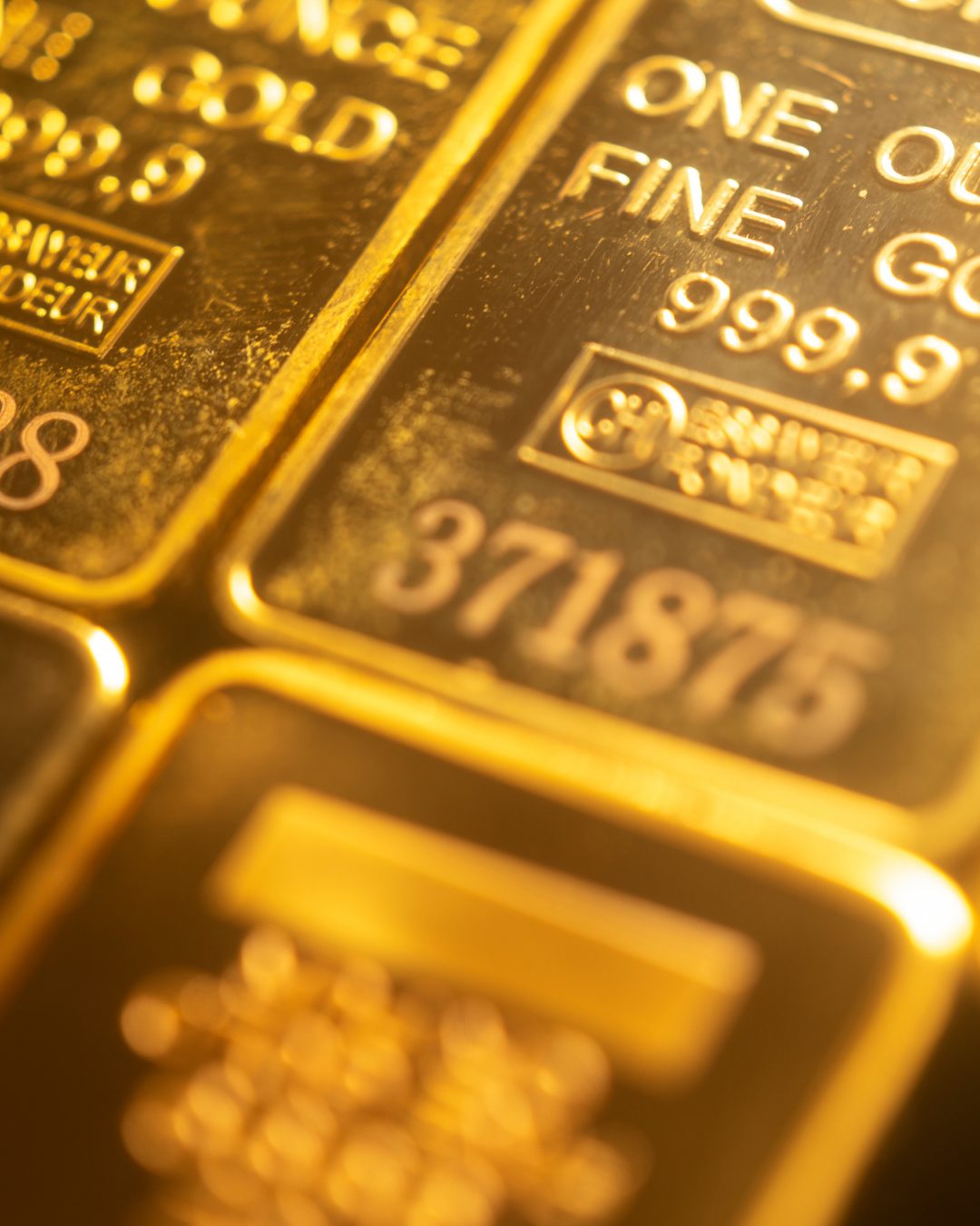 Close-up of stacked one-ounce fine gold bullion bars stamped 999.9
