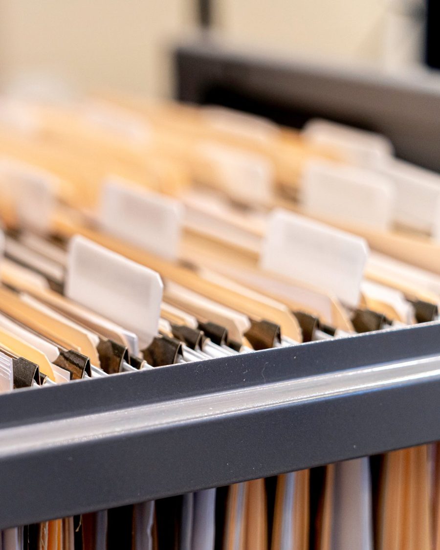 An open filing cabinet drawer full of paper documents in hanging folders, the storage a house fire would destroy