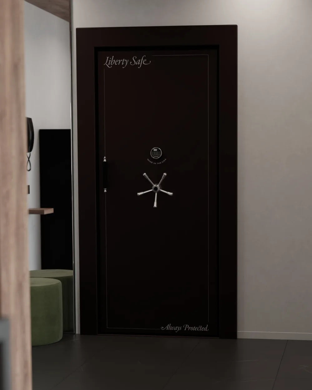 A black Liberty vault door with a chrome five-spoke handle and electronic lock, set into the wall of a modern residential room
